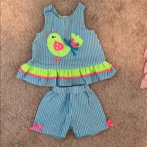 green and pink bird on bright blue top and shorts